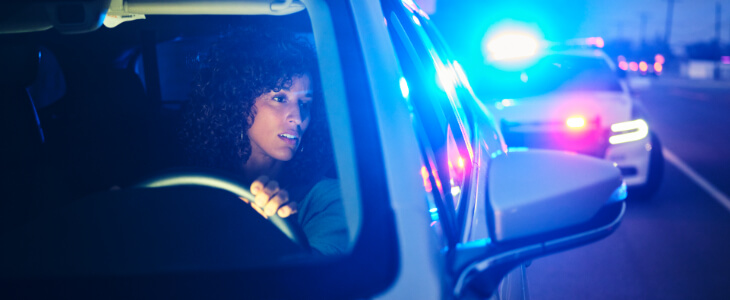 image of woman in car being pulled over by police